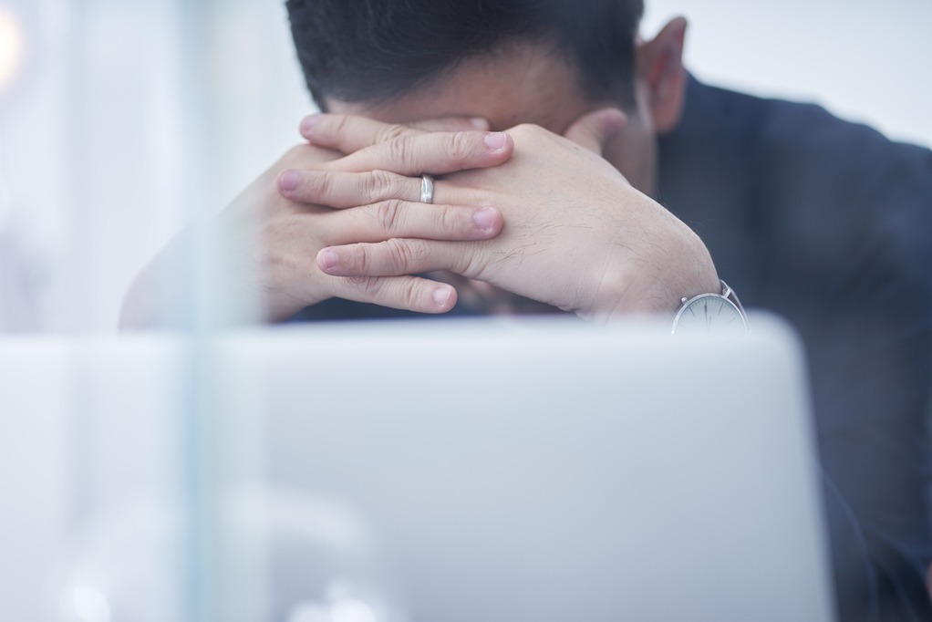 Stressed man or businessman at office, failure and headache concept